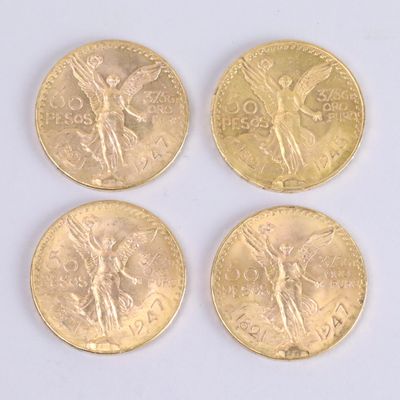 four gold coins with angel on them sitting on a white surface