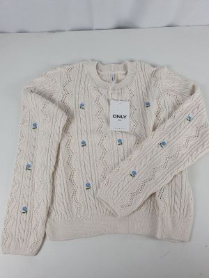 the sweater is white and has blue buttons on it