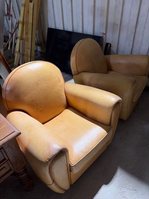 deux fauteuils en cuir et une table dans une pièce