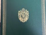an old book with gold trim and a green cover