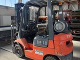 un chariot élévateur rouge garé à l'intérieur d'un entrepôt