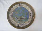 a decorative plate with a bird on it on a table
