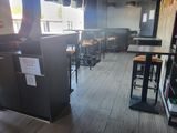 une photo d'un restaurant avec un réfrigérateur et des tabourets de bar