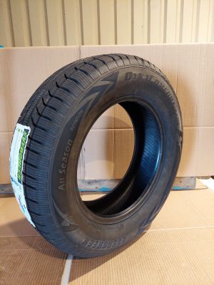 un pneu posé par terre devant une boîte en carton, avec une autre boîte en carton en arrière-plan