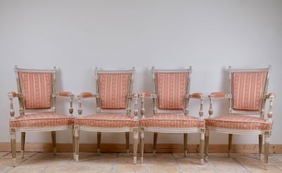 four chairs are lined up against a white wall in a room