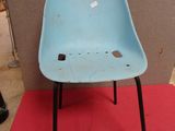 a blue plastic chair sitting on a red mat