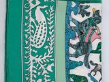 a green and white napkin with a picture of elephants on it
