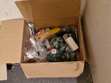 a cardboard box full of assorted items in the corner of a room
