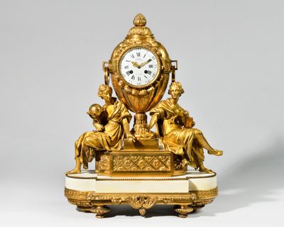 une horloge en or posée sur un socle en marbre