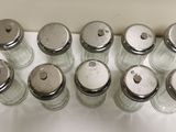 several salt and pepper shakers lined up on a counter top
