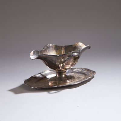 un plateau en argent orné d'une fleur, posé sur une table