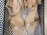 pair of nude colored shoes in a box on a white surface