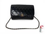 a black chanel bag with a chain on a white background