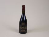 an old bottle of wine sitting on a table with a white background