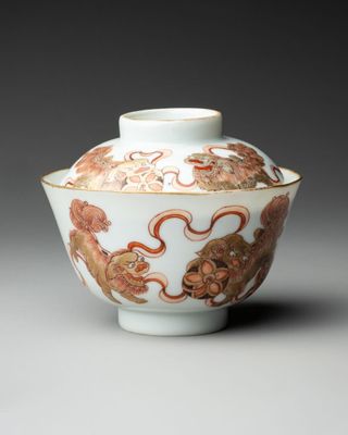 a close up of a white and red vase with a dragon on it