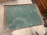 a green chalk board sitting on the floor next to a dresser
