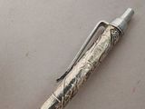 a silver pen that is laying on a table