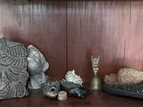 une étagère sur laquelle se trouvent une horloge, des bougies et des figurines