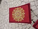 a red rug with a gold design on it
