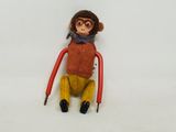 a stuffed monkey sitting on a chair with a scarf on
