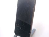 a broken cell phone sitting on a stand on a table