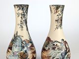 une paire de vases ornés de scènes asiatiques, posés sur une surface blanche