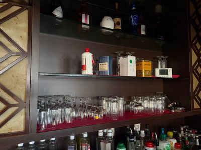 de nombreuses bouteilles et verres sur les étagères du bar
