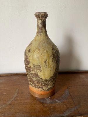 un vase marron et jaune posé sur une table en bois