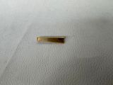 a small piece of gold on a white surface