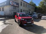 a red suv parked in front of a building