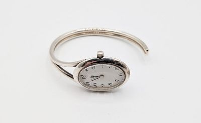 une image représentant une bague en argent sur laquelle figure une horloge