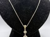 un collier en or blanc orné de trois diamants, porté par un mannequin noir