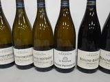 six bottles of wine are lined up in a row on a table