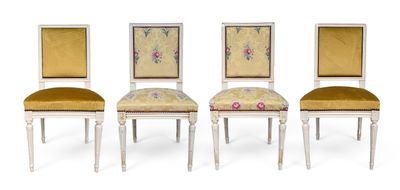 three white chairs with yellow upholstered cushions and a floral design