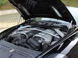 a black car with its hood open and the engine in the trunk