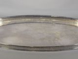 un plateau en argent posé sur une table blanche, sur fond blanc