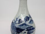 un vase bleu et blanc posé sur une surface blanche