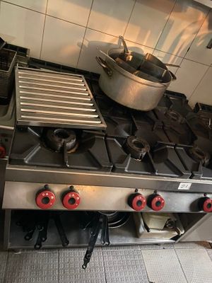 une cuisinière sur laquelle est posée une marmite dans une cuisine