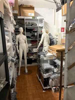 deux mannequins debout dans une pièce remplie de cartons