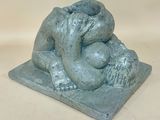 statue of a woman holding a baby in her arms on a stone base