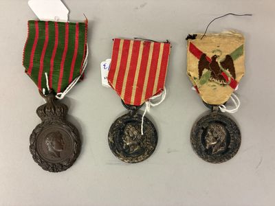 trois médailles et une médaille posée sur une table, accompagnée d'une étiquette