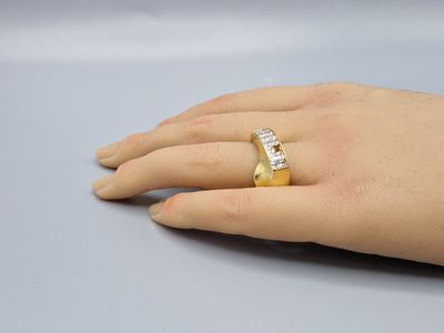 la main de quelqu'un, avec une bague en or sertie de diamants au doigt