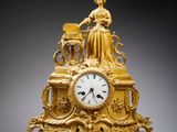 l'image d'une horloge en or posée sur une table