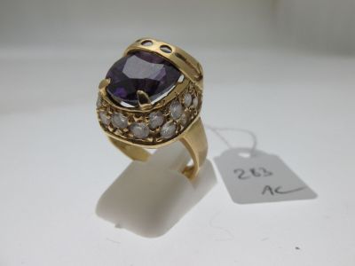 un gros plan d'une bague en or sertie d'une pierre violette