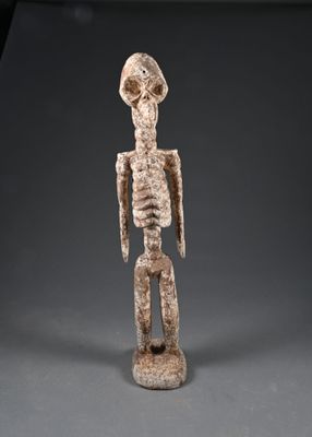 une statue représentant un personnage humain avec un crâne sur la tête