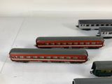 several toy trains are lined up in a row on a white surface