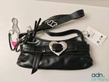 un sac à main noir orné d'une boucle en forme de cœur