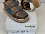 des chaussures Babybotte marron et beige posées sur une boîte, sur une surface blanche