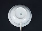 a white cup and saucer with a spoon on a black table