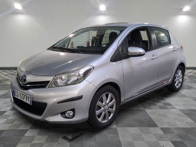 La Toyota Yaris argentée est garée sur un sol en carrelage à damier.